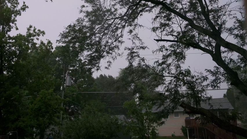Heavy rain, with loud thunder and lightning, a suburban residential street. Wide view footage