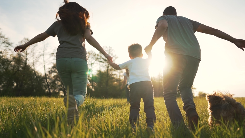 Happy family on grass with pet. Picnic in park with dog. Summer vacation on green meadow.People play run on grass.Family run in nature holding hands.Animal love for people.Family walk with dog in park | Shutterstock HD Video #1091625949