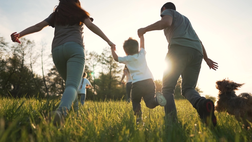 Happy family on grass with pet. Picnic in park with dog. Summer vacation on green meadow.People play run on grass.Family run in nature holding hands.Animal love for people.Family walk with dog in park | Shutterstock HD Video #1091625949
