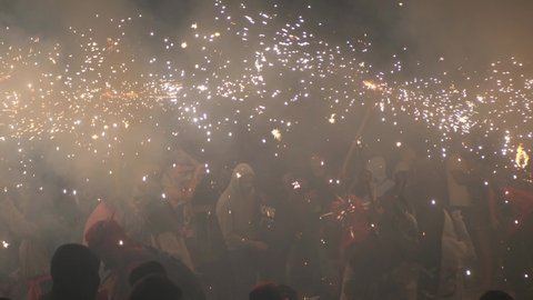 Palma de Mallorca, Spain; June 23rd 2022: Crowd of people dancing with the demons and fireworks in the night of San Juan 2022 in Parc de la Mar, Palma de Mallorca