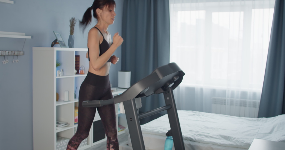 Young women do workout at home running exercising on Treadmill. Burn calories concept | Shutterstock HD Video #1091628007
