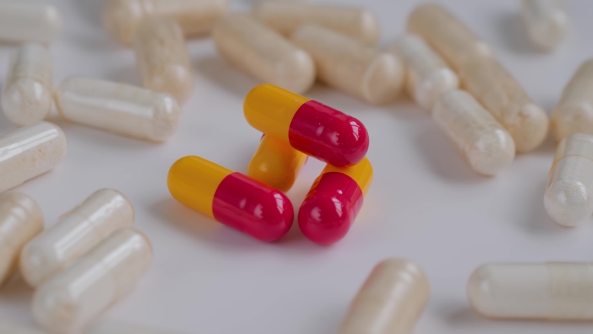 Close up: pills, tablets, drugs, meds, medications or supplements rotating on white surface. Healthcare, pharma industry, medicine, sample and pharmaceutical concept | Shutterstock HD Video #1091629045