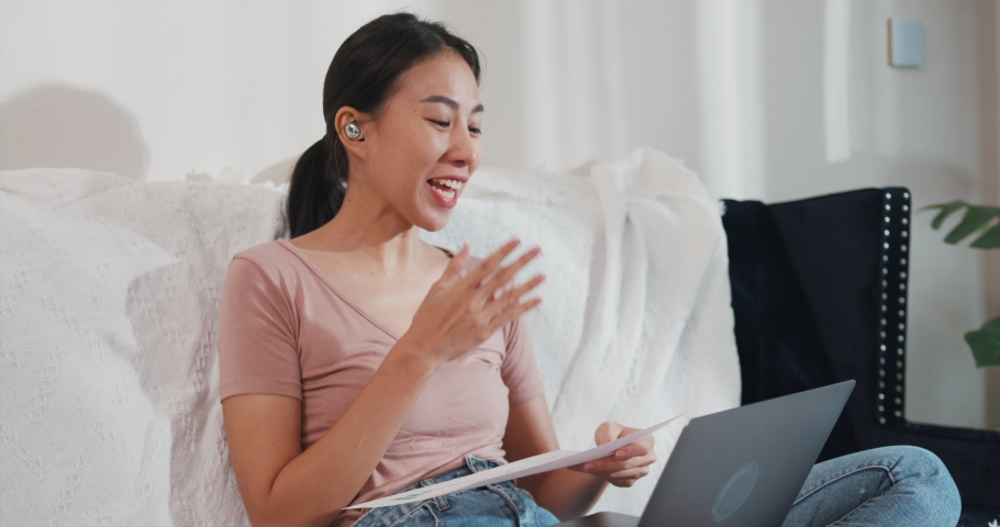 Asia businesswoman using laptop talk to colleagues about plan in video call while working from house at living room. Remotely at workplace, social distancing, quarantine for corona virus prevention. | Shutterstock HD Video #1091631575