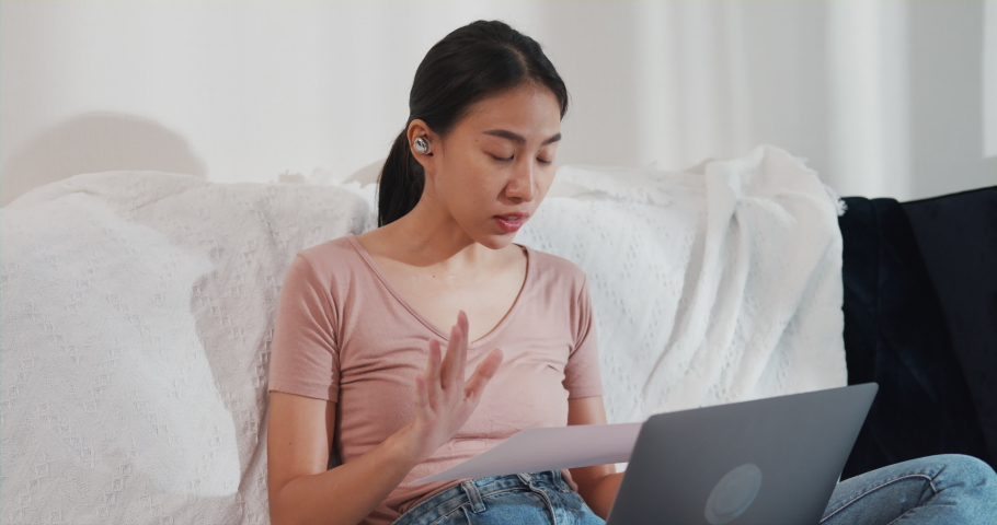 Asia businesswoman using laptop talk to colleagues about plan in video call while working from house at living room. Remotely at workplace, social distancing, quarantine for corona virus prevention. | Shutterstock HD Video #1091631593