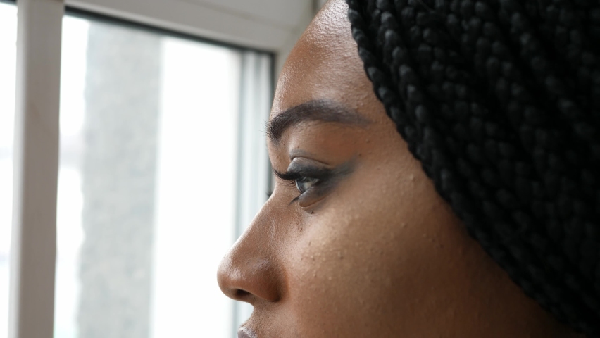 Close-up of the face of a thoughtful young woman looking towards the window thinking about life, affairs, problems and the future | Shutterstock HD Video #1091633805