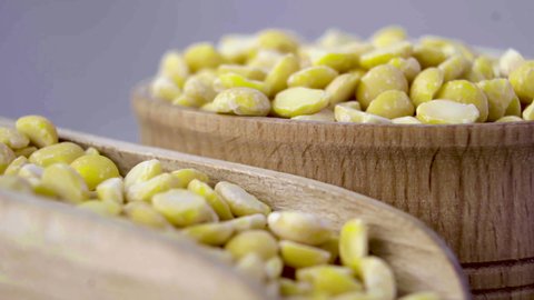 A variety of beans. Split grains of yellow peas in a wooden bowl