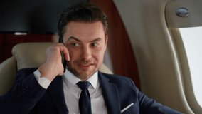 Portrait successful businessman calling partner on corporate airplane trip. Happy stylish man talking cellphone in private jet. Confident smiling financial manager discussing business deal at window. - Powered by Shutterstock - Get 15% off with code: PIKWIZARD15