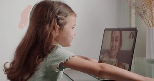 Little girl blows kiss to mother on video call via laptop