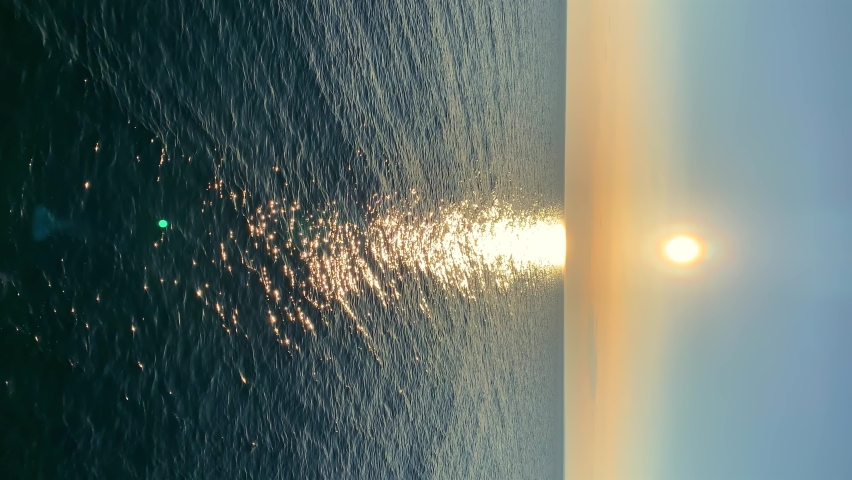 Vertical wave sea water movement. Ocean sunset. sun sets below horizon. Sunbeams on ocean. Sea holidays. Nature without people. Waves from the wind in the morning. Sea surf. Blue sky at dawn. | Shutterstock HD Video #1091653215