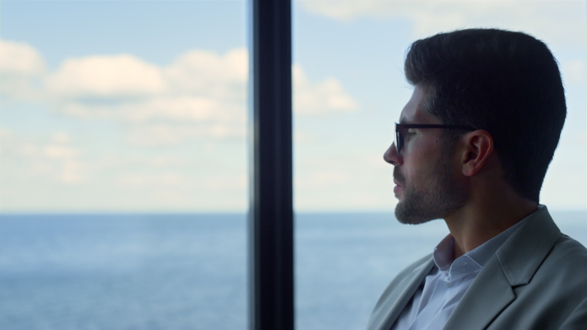 Pensive businessman looking window closeup. Stressed guy contemplating sea view. Successful focused man adjusting glasses considering future business planning. Attractive manager wait client in office | Shutterstock HD Video #1091654717