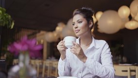 Latin woman in a cafe drinking coffee. Slow motion. Cinematic 4K - Powered by Shutterstock - Get 15% off with code: PIKWIZARD15