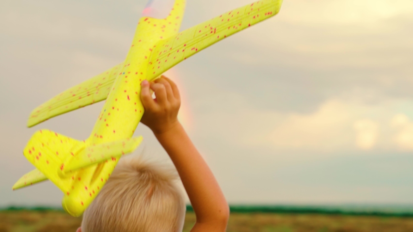 Boy wants to become pilot, astronaut. Slow motion. Happy boy runs with toy airplane on field in sunset light. Child play toy airplane. Teenager dreams of flying and becoming pilot. Plane, hand, child | Shutterstock HD Video #1091655617