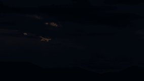 Timelapse video of sunrise sky with rain and storm clouds above mountains and dam within twilight time. 