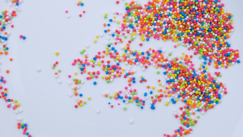 Rainbow sprinkle sugar on a white background | Shutterstock HD Video #1091657039
