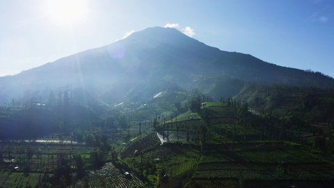 Aerial view of terraced farm fields near foothills Rinjani mountain in Lombok near Bali, Indonesia. Shot in 4k resolution from a drone flying forwards