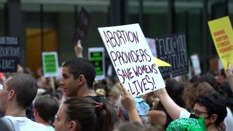 Chicago, Illinois - June 24 2022: Pro-choice pro-abortion protests in downtown Chicago after overturning of Roe v. Wade, person holding sign "Abortion Providers save women lives" up 