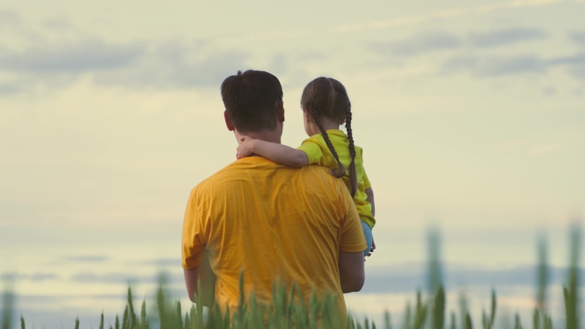 Agriculture. father carries child his arms. family walk through field with green wheat. farming. farmer walks across field with kid child daughter. growing green wheat. daddy care for child girl | Shutterstock HD Video #1091658967