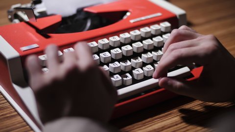 Red typewriter. Vintage objects. Men's hands press buttons.