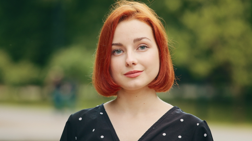 Close up outdoors portrait of human female face caucasian young girl redhead woman lady smiling outside nodding head yes answers approval sign agree positive agreement approval support posing flirting Royalty-Free Stock Footage #1091662047