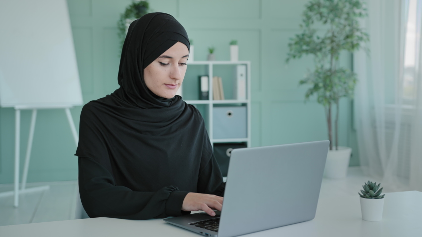 Busy Islam businesswoman in black hijab freelancer Islamic Arabian girl student worker Muslim woman female with laptop working e-learning typing online chat e-commerce app web browsing in network Royalty-Free Stock Footage #1091662075
