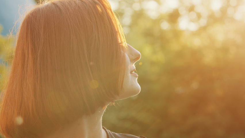 Close up beautiful female profile face redhead teen girl woman with short trendy hairstyle attractive smiling young model fix hair posing outdoors look at sunset sky enjoy sunbeams in summer weather