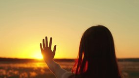 Silhouette of hand in sun. Happy girls stretches her hand to sun. Glare of sunset on fingers of young woman. Prayer of woman, religion of world. Girl travels at sunset. Girl walk at sunset. Prayer god