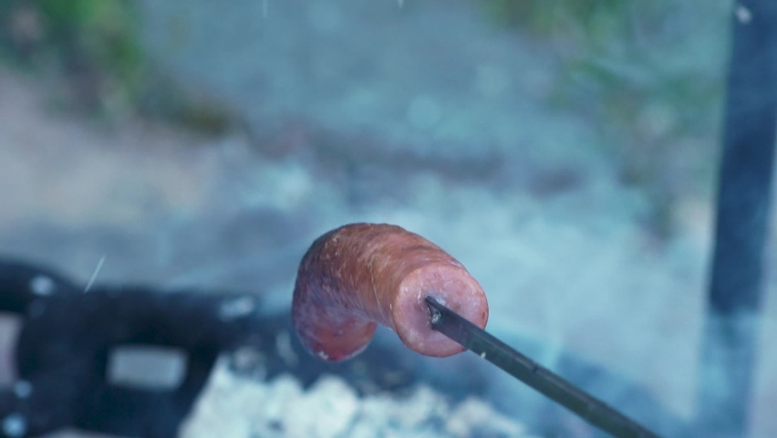Sausage on a spit over a campfire