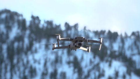 CLOSE SHOT Delivery by unmanned aerial vehicle. Mavic2 drone on the background of snow-capped mountains. copter in the air