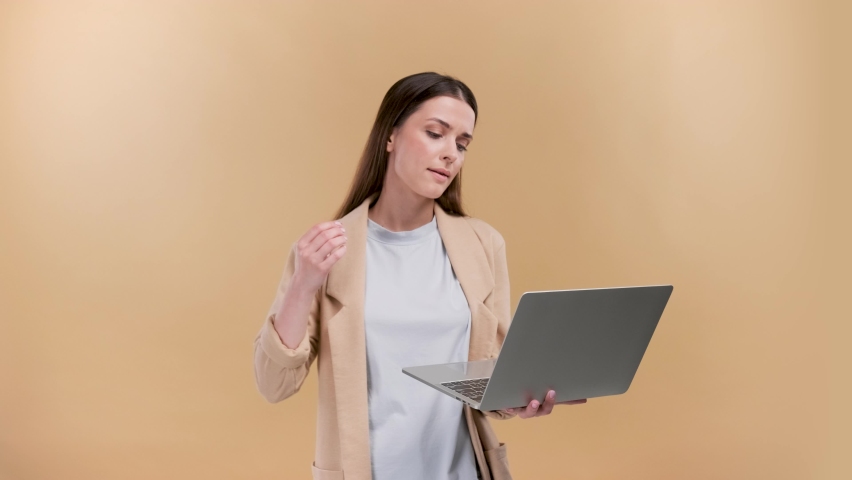 business womn closing her lap top with anger and frustration over beige background