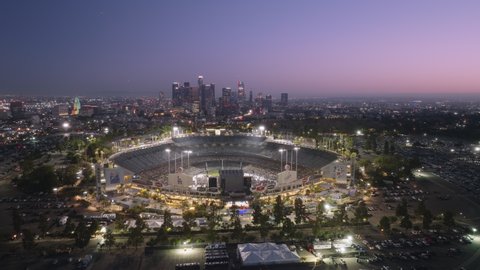 Dodgers Stadium at night, LOS ANGELES CA, USA June 2022. Drone aerial shot 4K Baseball stadium in downtown Los Angeles. View of LA skyline skyscrapers buildings. Urban modern city in America at sunset