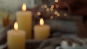 Defocused background Thanksgiving and Hello Fall Hygge atmosphere Autumn leaves and candle on cozy knitted sweater in warm yellow lights - Powered by Shutterstock - Get 15% off with code: PIKWIZARD15