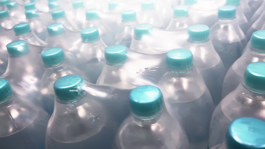 Two-liter bottles of mineral water packed in 6 bottles stand in warehouse. Close-up shot. Royalty-Free Stock Footage #1091692939