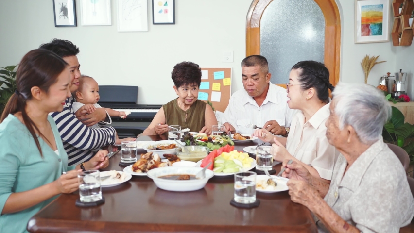 Happy big Asian family having dinner together at home