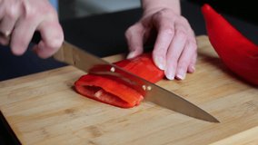 Cutting red peppers at home close up