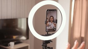 Recording new video on smartphone, woman having live stream on cell phone at home, beauty blogger live broadcasting spanish language teacher tutorial on social media. Vlogger recording vlog video