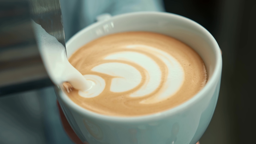 Barista making latte art in specialty coffee shop. Professional man making pouring stream milk with espresso | Shutterstock HD Video #1091709191