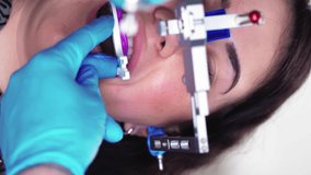 Vertical Video Professional Dentist in Medical Gloves Assistant Using Special Tool Examines Female Patient in Dental Clinic. Dental Treatment and Care Modern Dentistry. Concept Healthcare and Medicine