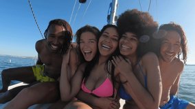 Happy multiracial friends streaming live video while doing sea tour with sailing boat