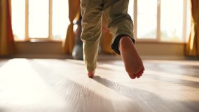 Baby takes first step on floor to his mother with bare feet.Son and mother at home feet on floor.Happy boy barefoot on laminate.Baby foot on wooden floor.Child is learning to walk.Happy family concept - Powered by Shutterstock - Get 15% off with code: PIKWIZARD15
