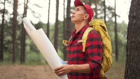 Tourist with map in forest park. Rest at nature. Hiking in forest park. Orientation on map in forest. Tourist travels on foot. Orientation on map for trip. Tourist rest in natural park - Powered by Shutterstock - Get 15% off with code: PIKWIZARD15
