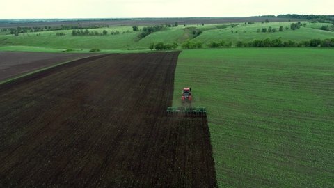 Agriculture. Tractor work on green field. Aerial survey of farm. Farmer in wheat field Tractor work on farm. Landscape of field. Agriculture concept. Farmer work with green wheat. Aerial wheat field