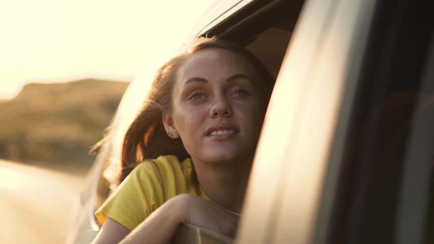 Child in car window. Family car trip. Child hair in wind. Girl looks out of car window. Happy child travel with his family. Girl stretches out his hand to wind. Happy family travel concept by car | Shutterstock HD Video #1091738801