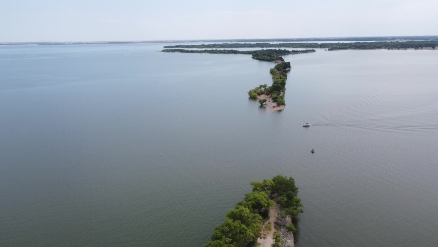 Aerial view boat approaching the original breach of Lake Dallas Dam aka The Cut divides upper, lower halves of Lake Lewisville. Formerly known as Garza-Little Elm Reservoir in Denton County, Texas
