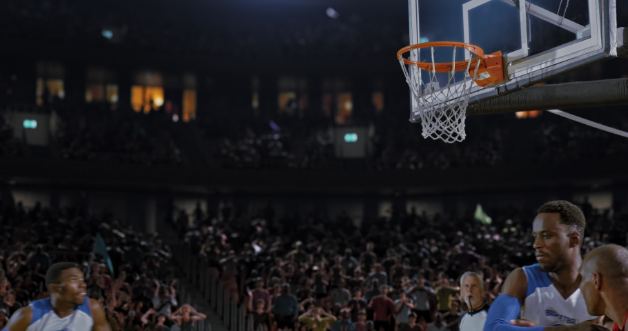 Basketball player throwing the ball into the hoop in a jump and scoring points. Opposite team player blocking. Players celebrating. 3d made basketball stadium with animated crowd. Royalty-Free Stock Footage #1091740149