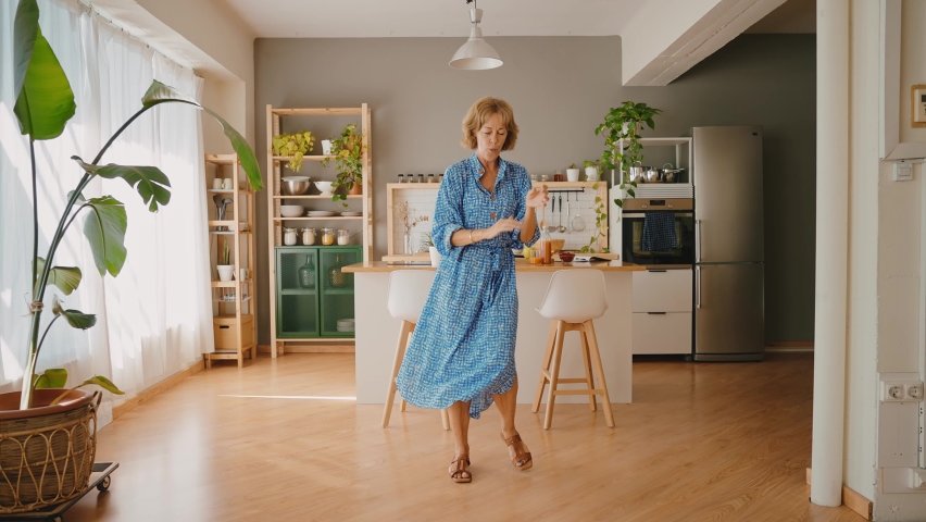 Cinematic storytelling footage of a beautiful senior woman spending time in her cozy apartment, doing daily lifestyle activities. Dancing and having fun Royalty-Free Stock Footage #1091741019