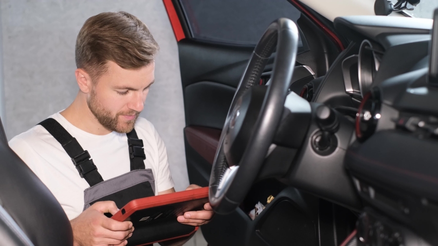 The mechanic maintains the vehicle with the help of diagnostic computer equipment - modern equipment | Shutterstock HD Video #1091748519
