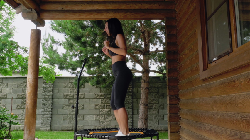 Young athletic woman exercising alone using a trampoline. Jumping fitness in outdoor. Active fat burning body workout. She jumps energetically | Shutterstock HD Video #1091756221