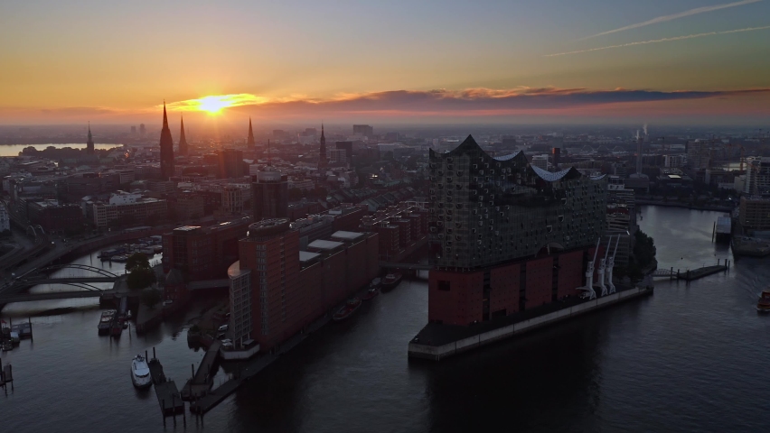 Establishing Aerial Shot of Hamburg at sunset, Mecklenburg-West Pomerania, Germany, magic light over the city, slow gentle inflow, River Elbe Royalty-Free Stock Footage #1091757605