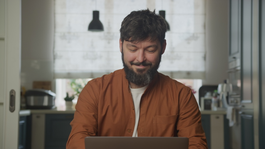 Smiling guy studying on a computer laptop 