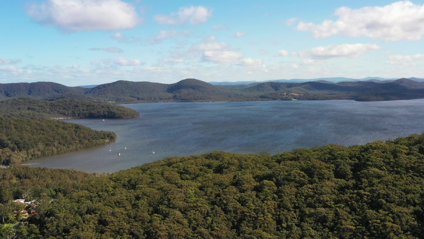 Slow aerial over trees fly to Wallis lake in Booti Booti NP of Austrlaia as 4k.
 | Shutterstock HD Video #1091759739